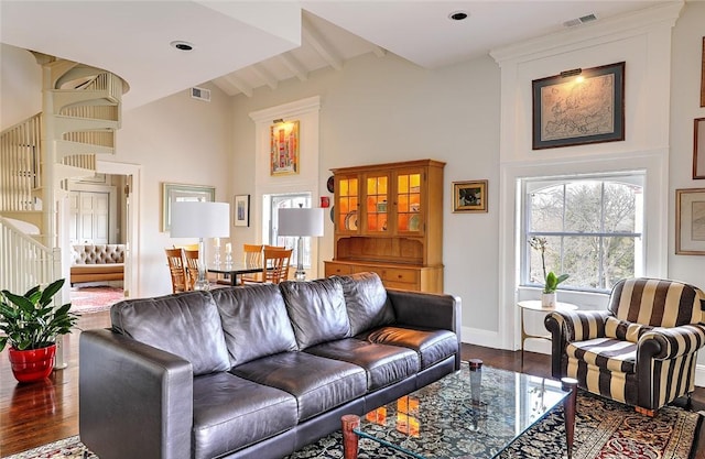 living room with high vaulted ceiling, stairway, visible vents, and wood finished floors