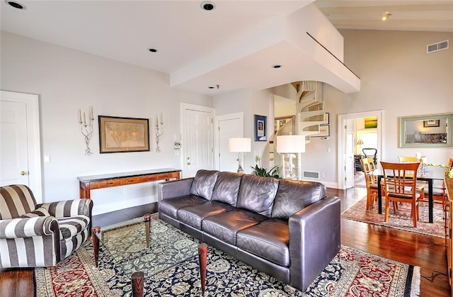 living room featuring visible vents, baseboards, and wood finished floors