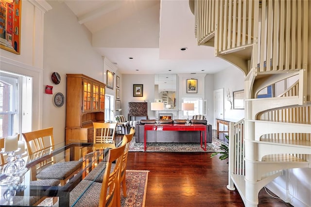 dining area featuring a healthy amount of sunlight, high vaulted ceiling, and dark wood finished floors