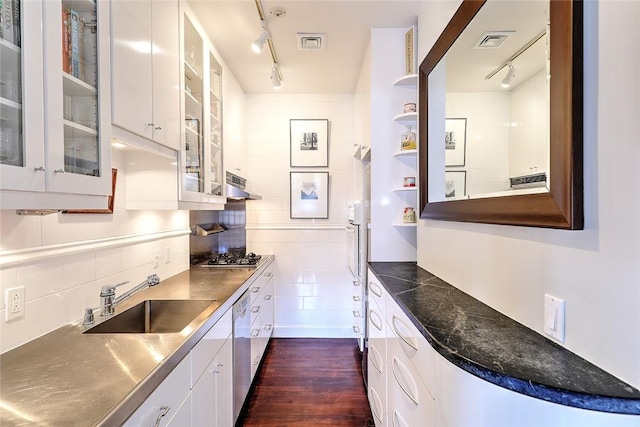 kitchen featuring stainless steel countertops, a sink, white cabinets, open shelves, and glass insert cabinets