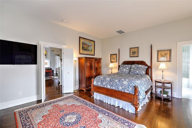 bedroom with dark wood-type flooring, visible vents, and baseboards