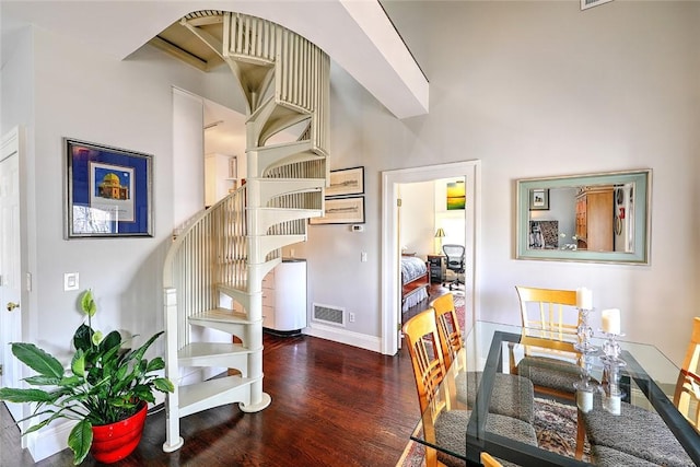 staircase featuring wood finished floors, visible vents, and baseboards