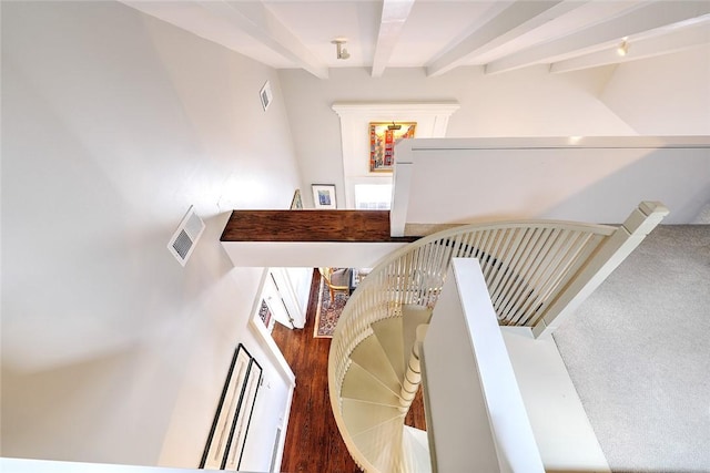 stairway with beamed ceiling, wood finished floors, and visible vents