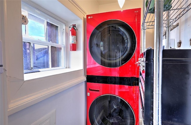 washroom featuring stacked washer / dryer and laundry area