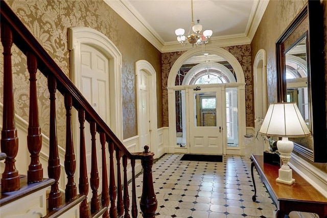 foyer featuring wallpapered walls, a notable chandelier, and a wainscoted wall