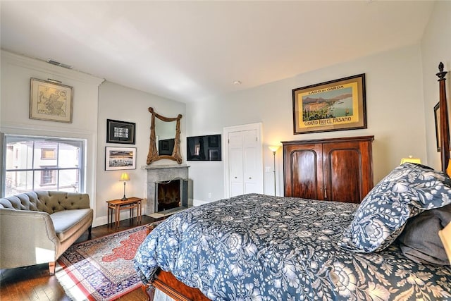 bedroom featuring a fireplace, baseboards, and wood finished floors