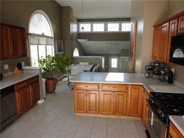 kitchen featuring black microwave, light countertops, gas range, and dishwasher