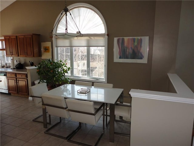 dining room featuring high vaulted ceiling and light tile patterned floors