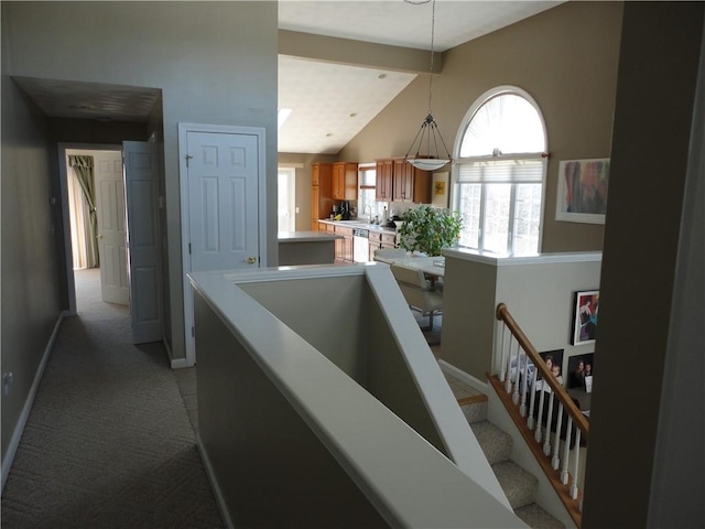 hall featuring light carpet, an upstairs landing, high vaulted ceiling, beamed ceiling, and baseboards