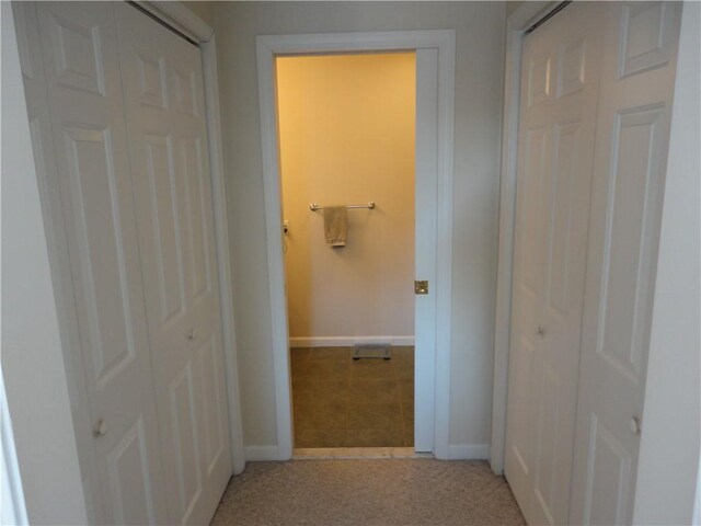 corridor with light carpet and baseboards