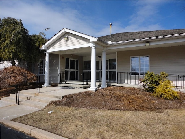 view of front of house with covered porch and a shingled roof