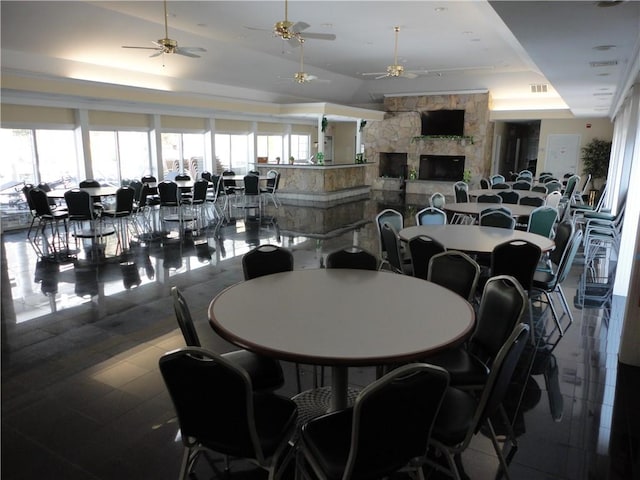 dining area with a healthy amount of sunlight, a fireplace, and a tray ceiling