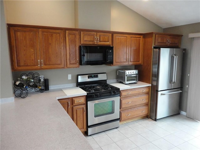 kitchen featuring appliances with stainless steel finishes, brown cabinets, and light countertops