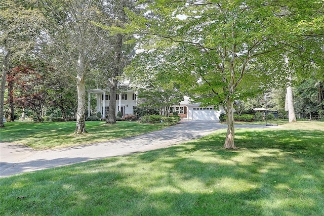 view of front of property featuring a garage, a front yard, and driveway