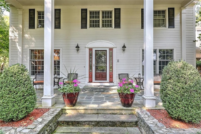 view of exterior entry featuring covered porch