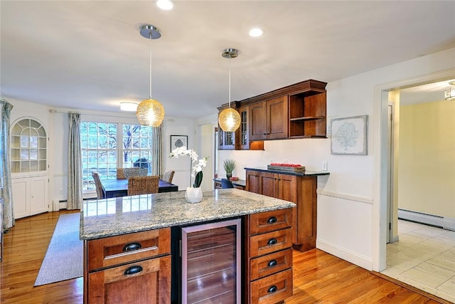 kitchen with beverage cooler, light stone counters, decorative light fixtures, light wood-style floors, and open shelves