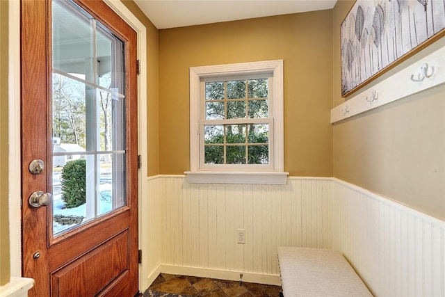 doorway to outside featuring wainscoting