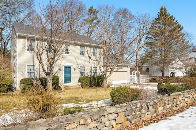 colonial home with a garage, a yard, driveway, and entry steps