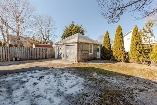 exterior space with a garage, driveway, fence, and an outdoor structure