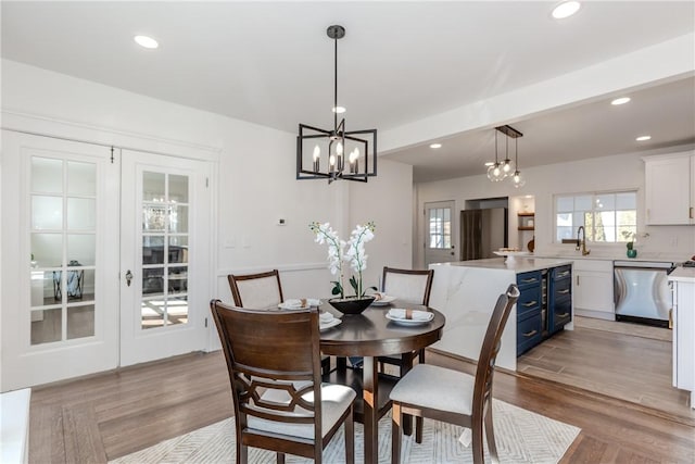 dining area with french doors, light wood finished floors, and recessed lighting