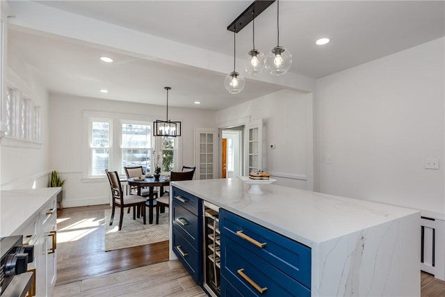 kitchen featuring blue cabinets, recessed lighting, pendant lighting, and light wood-style floors