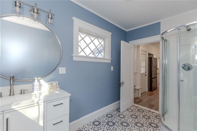 full bath with ornamental molding, baseboards, a shower stall, and vanity