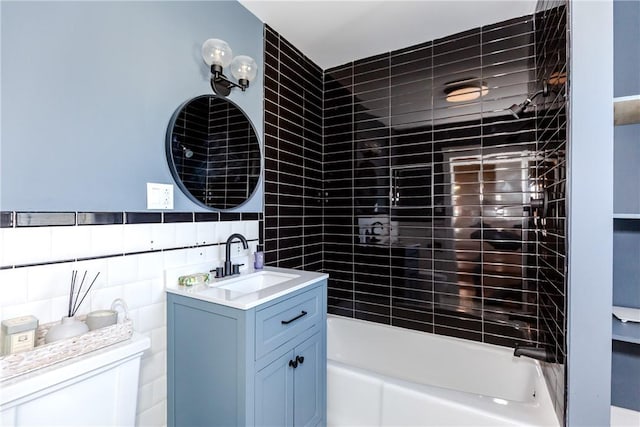 bathroom featuring  shower combination, vanity, and tile walls