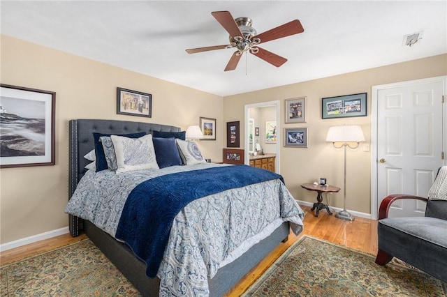 bedroom with visible vents, a ceiling fan, connected bathroom, wood finished floors, and baseboards