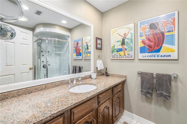 bathroom with visible vents, baseboards, tile patterned flooring, vanity, and a shower stall