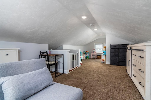 bedroom featuring lofted ceiling, baseboards, dark carpet, and a textured ceiling