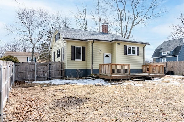 rear view of property featuring a gate, a chimney, a fenced backyard, and a wooden deck