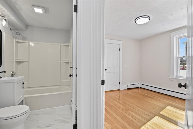 bathroom with toilet, wood finished floors, vanity, baseboard heating, and tub / shower combination