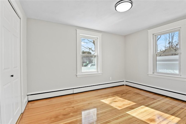 interior space featuring plenty of natural light, wood-type flooring, and a baseboard heating unit