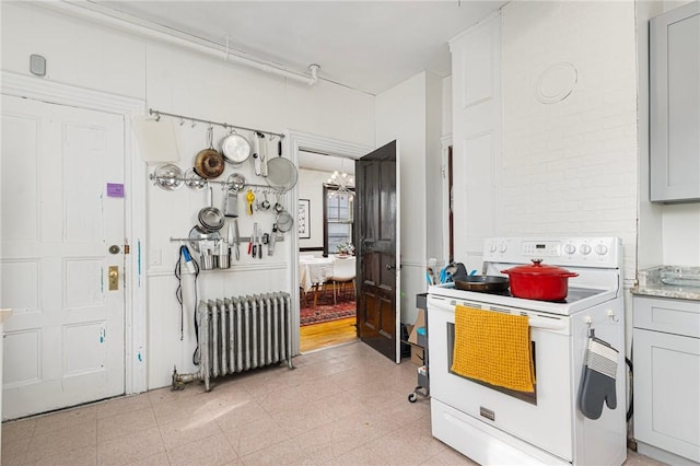 kitchen with light countertops, gray cabinets, white electric range, and radiator heating unit