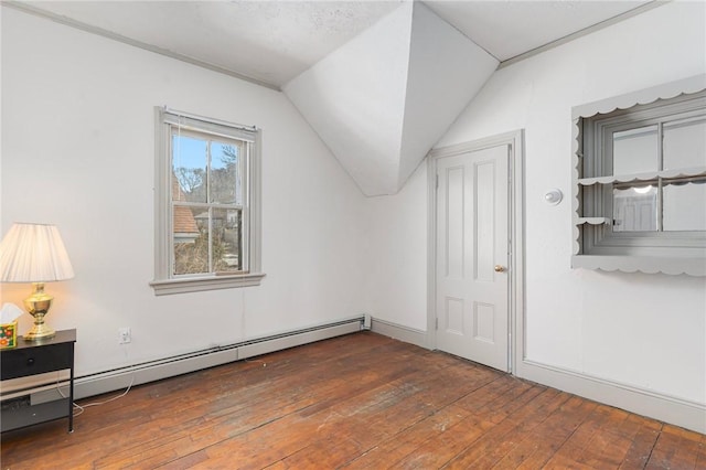 additional living space featuring lofted ceiling, a baseboard heating unit, and hardwood / wood-style floors