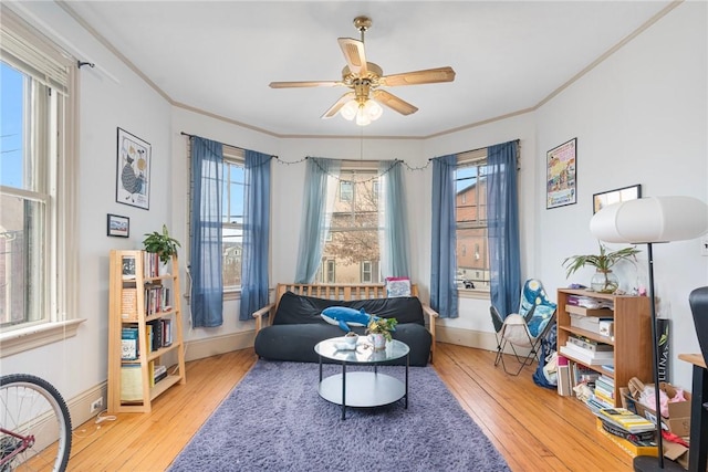 sitting room with ornamental molding, baseboards, and hardwood / wood-style floors