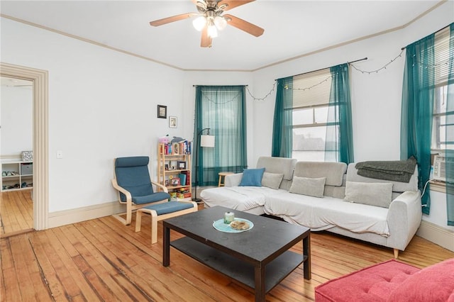 living area with wood-type flooring, baseboards, ceiling fan, and crown molding