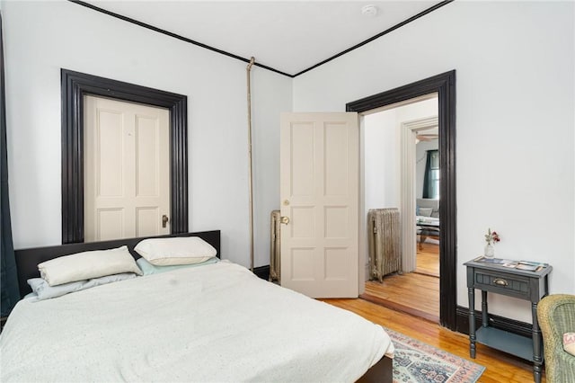 bedroom with ornamental molding and light wood-type flooring