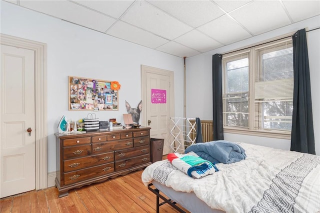 bedroom featuring a paneled ceiling and light wood-style flooring