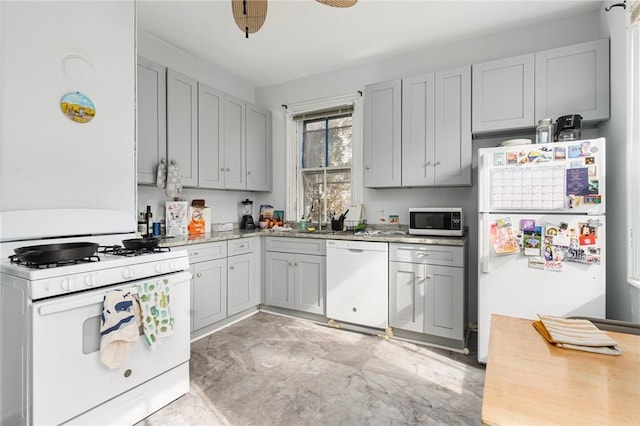 kitchen with gray cabinets, white appliances, and light countertops