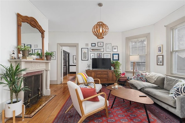 living area with a fireplace with flush hearth and light wood-style flooring