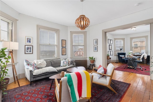 living room with radiator heating unit, baseboards, and hardwood / wood-style floors