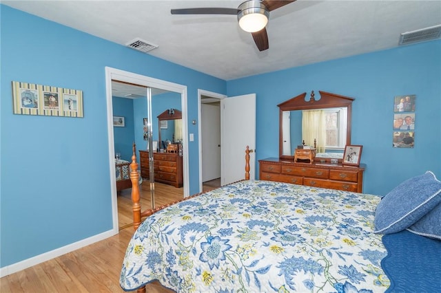 bedroom with baseboards, light wood-style flooring, visible vents, and a ceiling fan