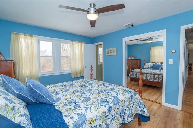 bedroom featuring a closet, visible vents, a ceiling fan, wood finished floors, and baseboards