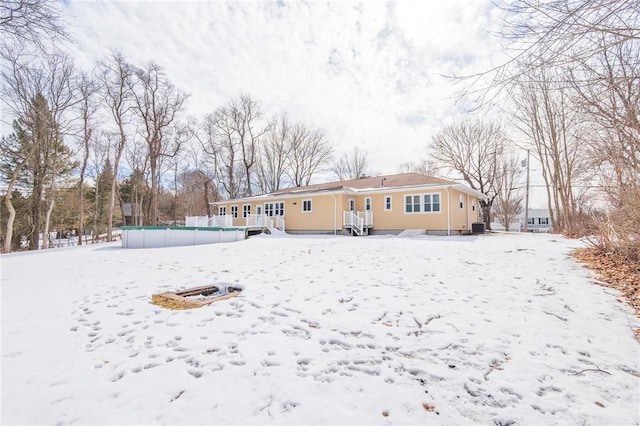 snow covered house featuring an outdoor pool