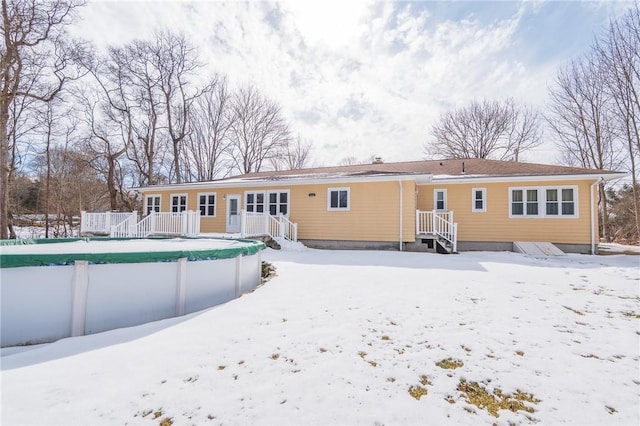 snow covered property featuring a covered pool