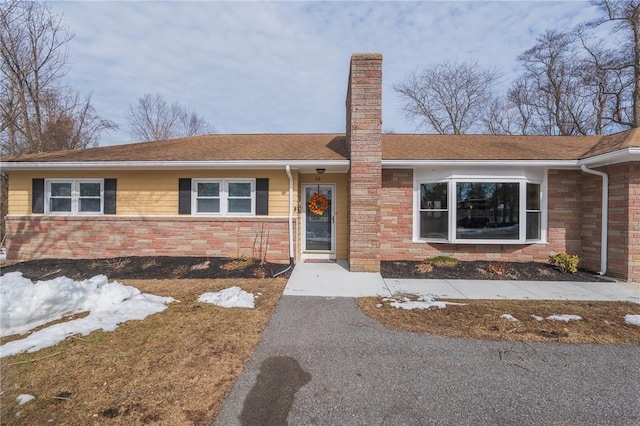 view of front of property with stone siding and a chimney