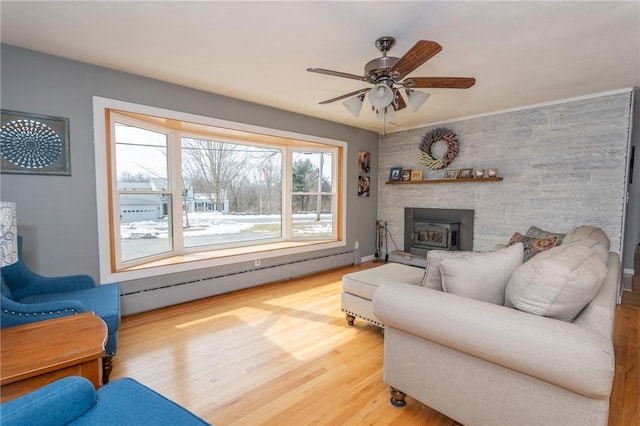 living area featuring a baseboard radiator, ceiling fan, and wood finished floors