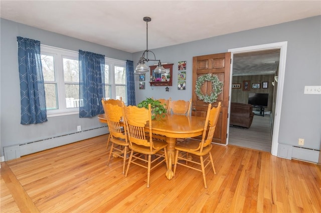 dining space featuring baseboard heating, a baseboard radiator, and wood finished floors