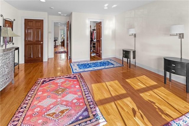 interior space with baseboards, wood finished floors, and recessed lighting